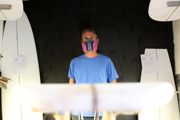 Michael Miller surfboard shaper standing in his shaping room 